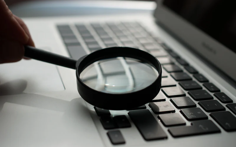 Magnifying glass next to a laptop